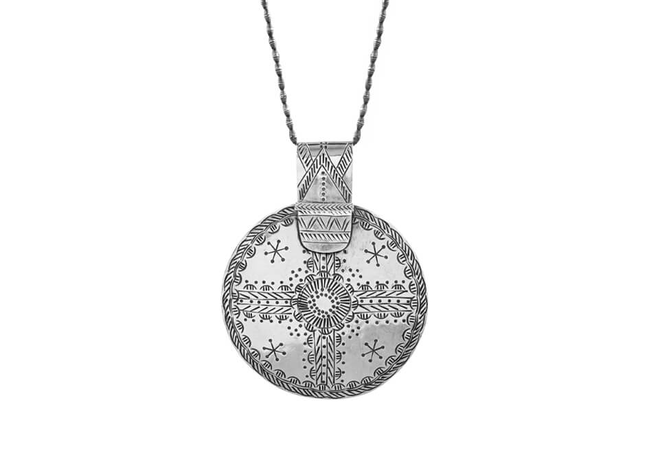 Photo showing a chunky tribal plate pendant with necklace over a white background